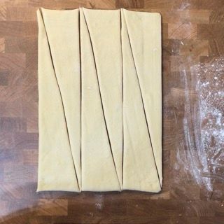 Un pezzo di pasta è appoggiato su un tavolo di legno.