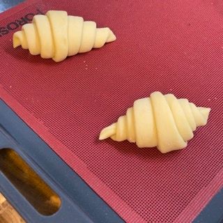 Due croissant sono appoggiati su un tappetino rosso con la scritta soho