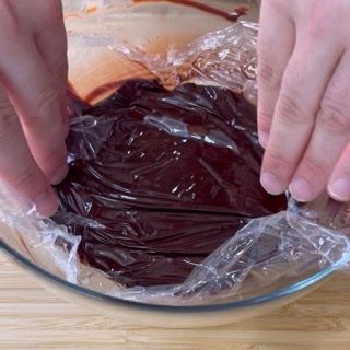 Una persona sta avvolgendo un pezzo di cioccolato nella pellicola trasparente.