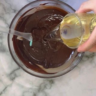 Una persona che versa del liquido in una ciotola di cioccolato