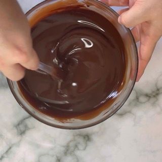 Una persona sta mescolando il cioccolato in una ciotola con un cucchiaio