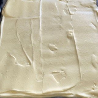 Un primo piano di un pezzo di glassa bianca su un tavolo.