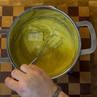 Una persona sta sbattendo un liquido giallo in una pentola