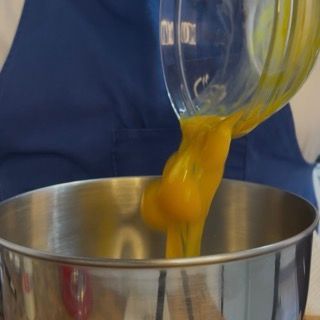 Un uovo viene versato in una ciotola di metallo.