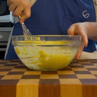 Una persona sta mescolando qualcosa in una ciotola con una frusta