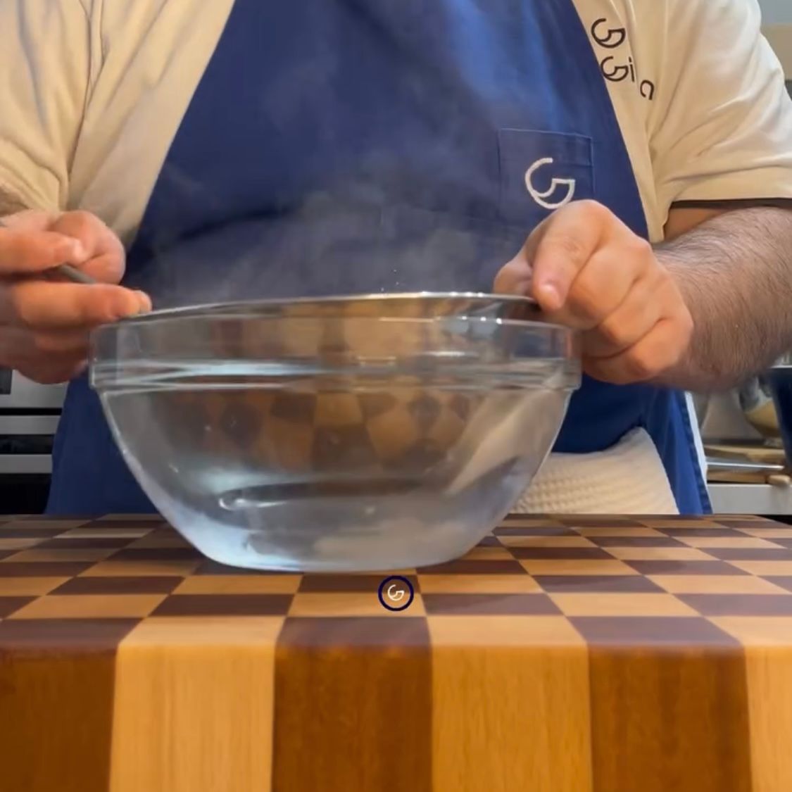 Un uomo con un grembiule sta mescolando una ciotola d'acqua