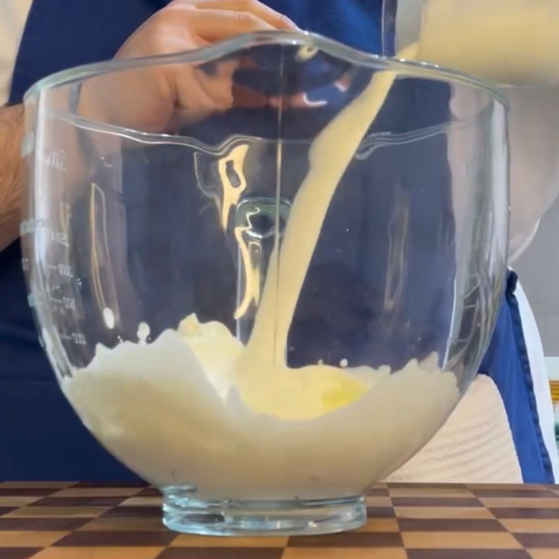 Una persona sta versando del liquido in una ciotola di vetro
