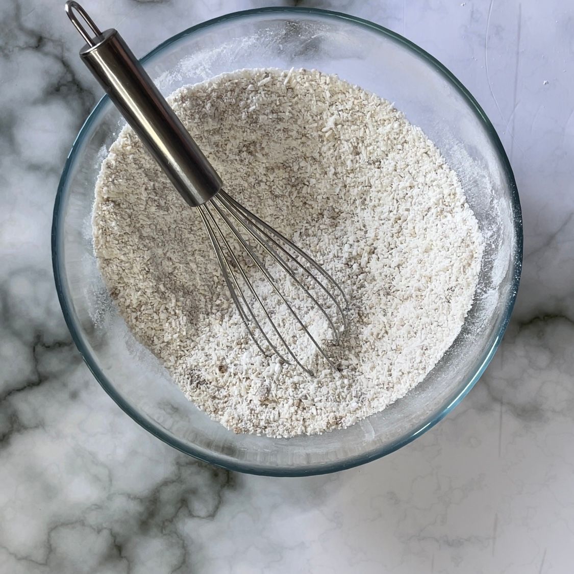 Una ciotola di farina con una frusta dentro