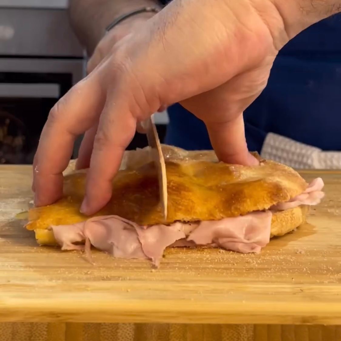 Una persona sta tagliando un panino con uno stuzzicadenti