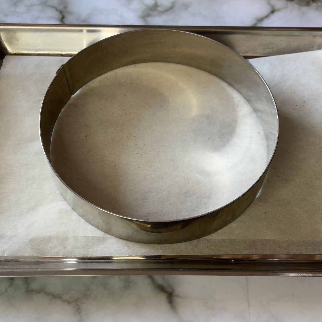 Un anello di metallo pieno di zucchero è appoggiato su un vassoio