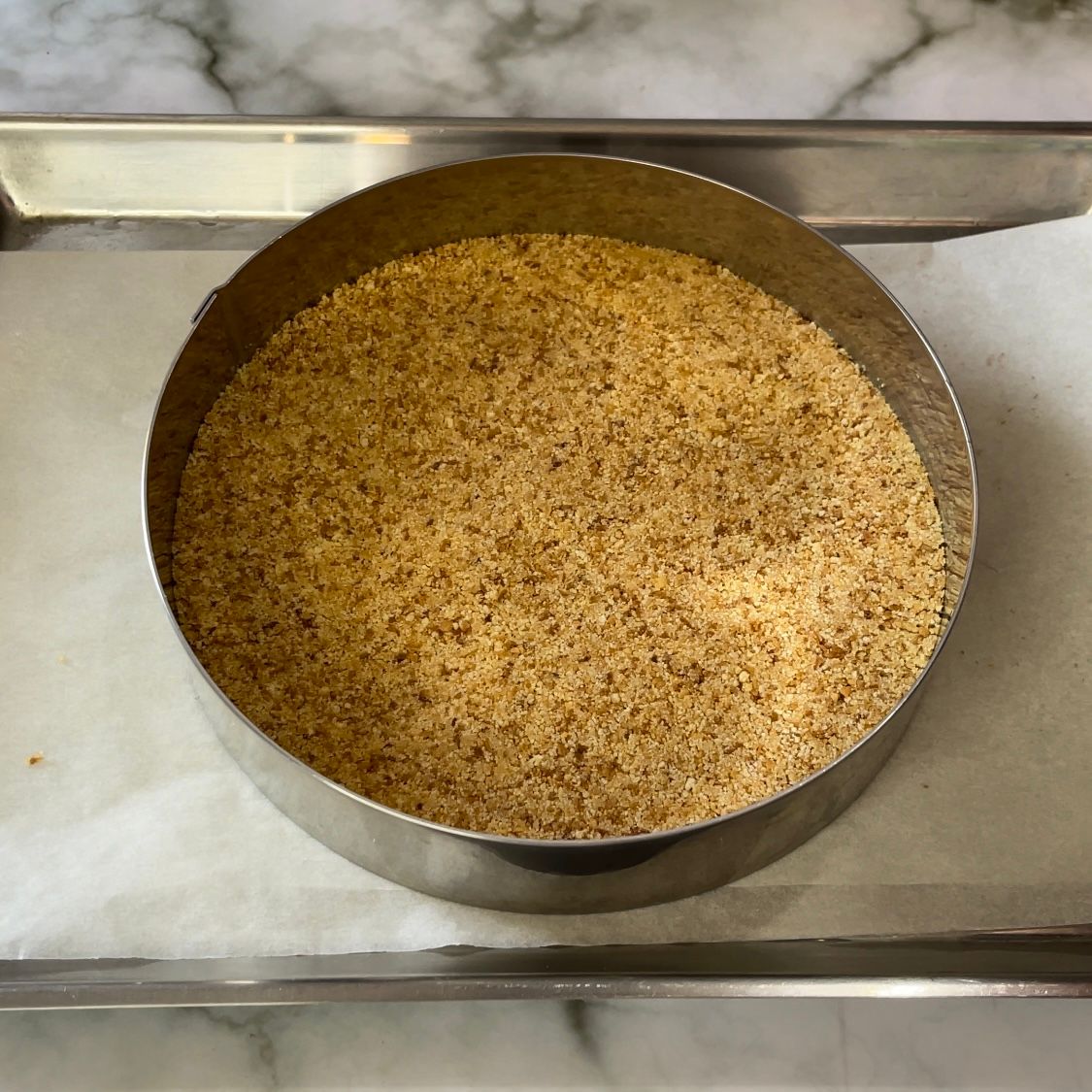 Un anello di metallo riempito con una sostanza marrone su un vassoio