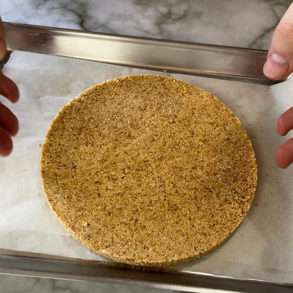 Una persona tiene in mano un pezzo di pane su un vassoio