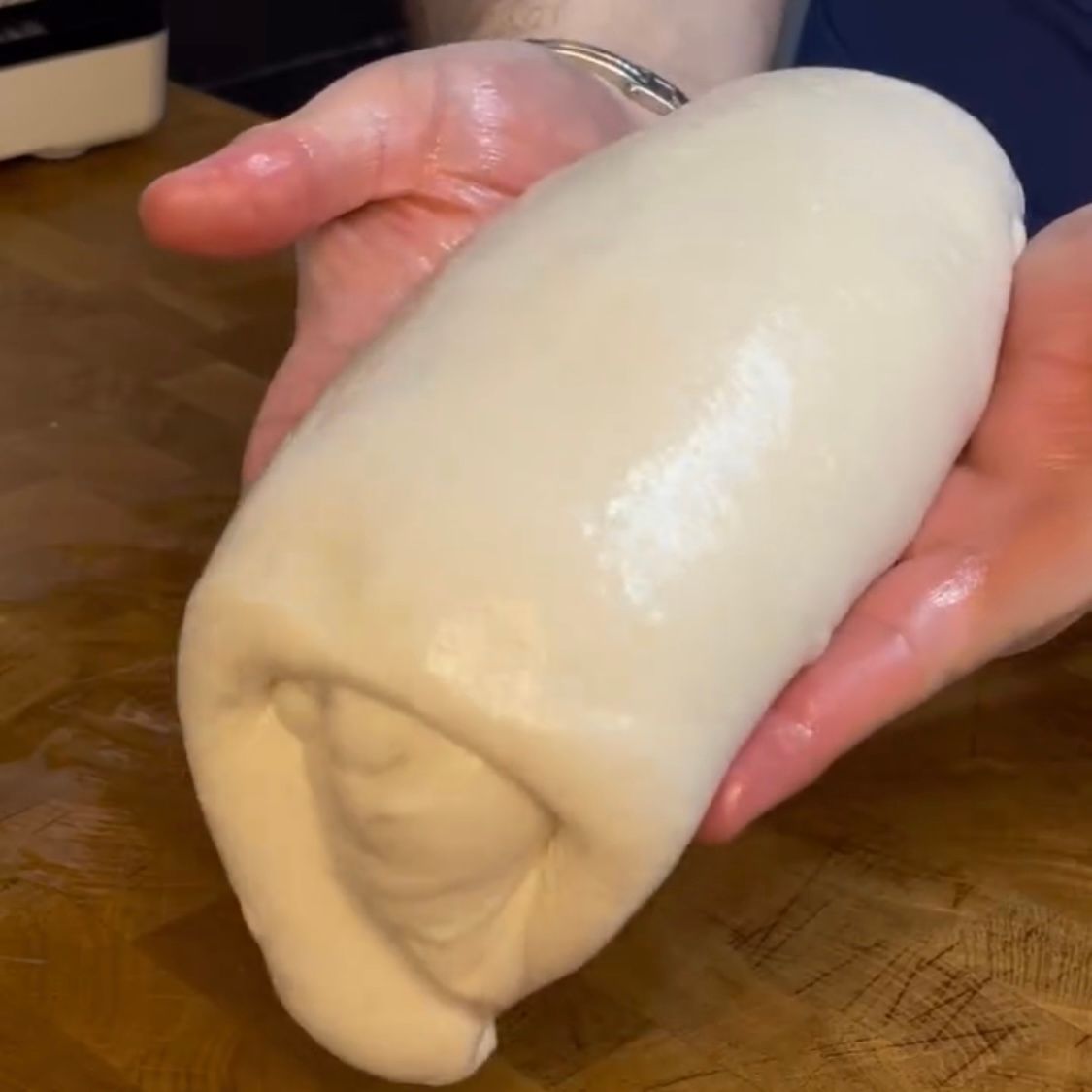 Una persona tiene in mano un grosso pezzo di pasta