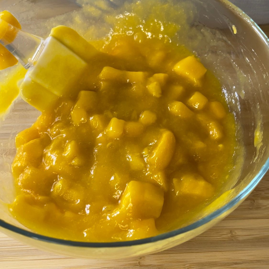 Una ciotola di salsa gialla con una spatola dentro.