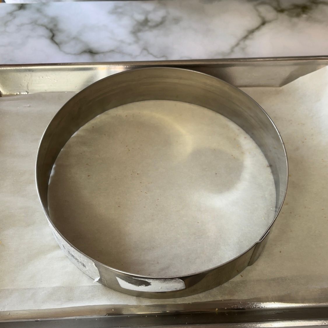 Un anello di metallo è appoggiato su un pezzo di carta oleata.