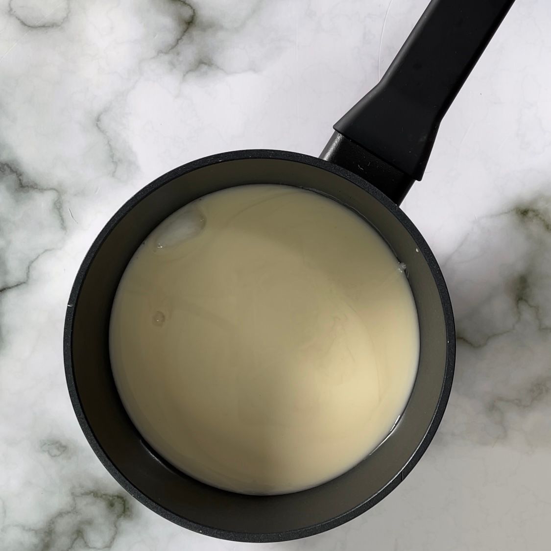 Una pentola di zuppa è appoggiata su una superficie di marmo.