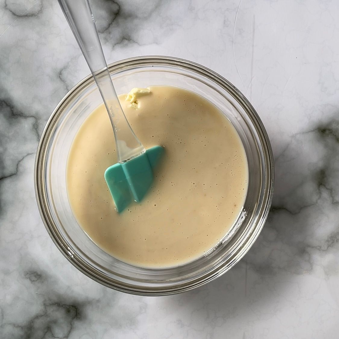 Una ciotola di salsa con una spatola verde dentro