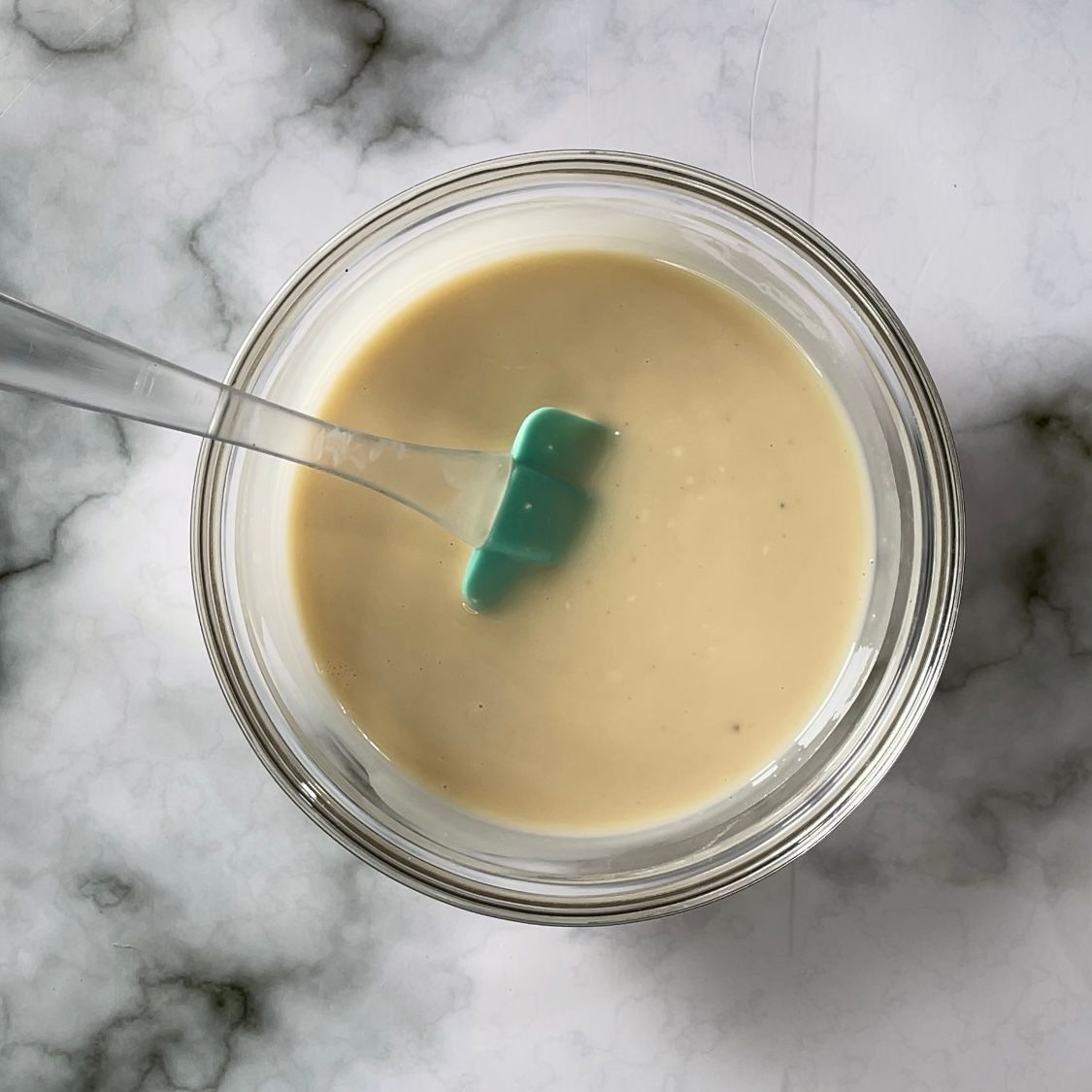 Una ciotola di zuppa con una spatola verde dentro