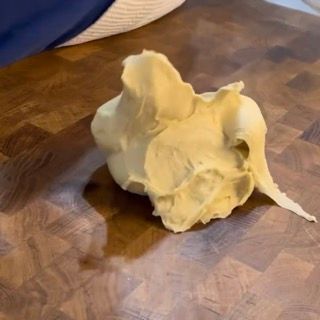 Un pezzo di pasta è appoggiato su un tagliere di legno