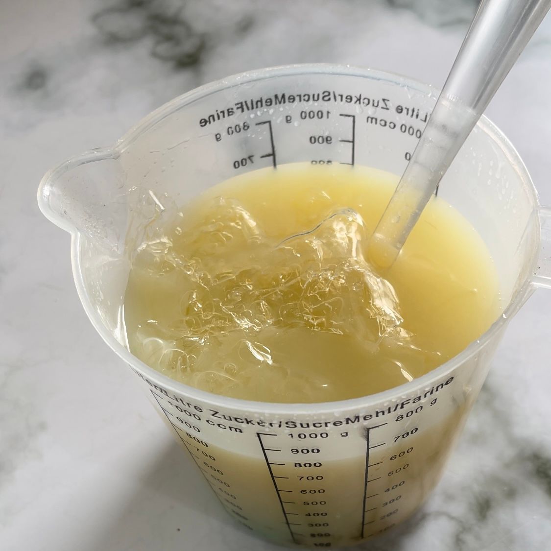 Un misurino pieno di liquido e una cannuccia