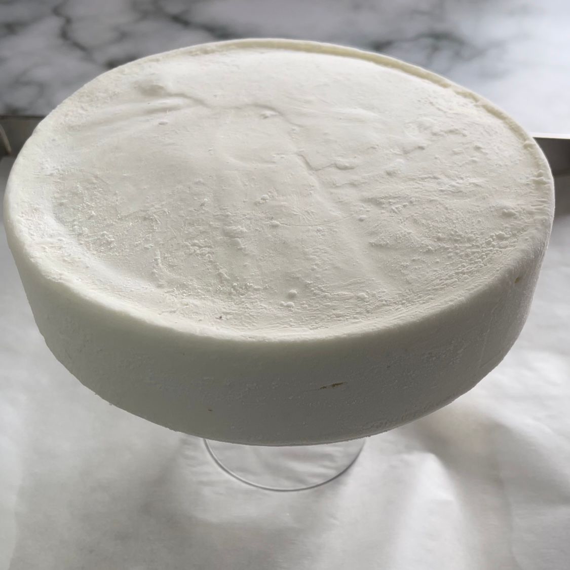 Un primo piano di un gelato bianco in un bicchiere su un tavolo.