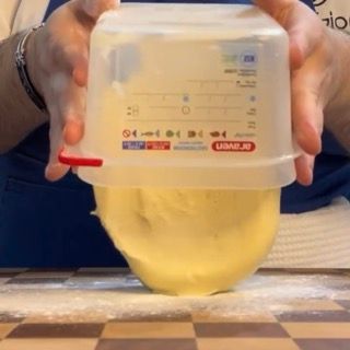 Una persona tiene in mano un misurino sopra una ciotola di impasto