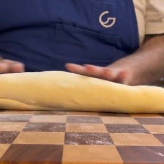 Una persona che indossa un grembiule blu con la lettera g sopra