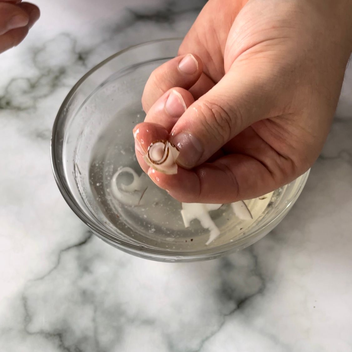 Una persona tiene un paio di orecchini in una ciotola d'acqua