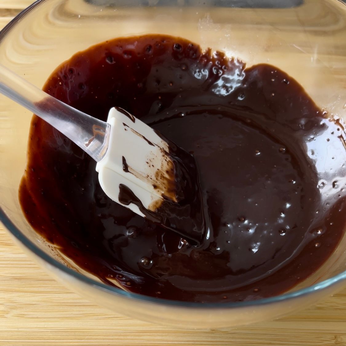 Una ciotola di salsa al cioccolato con una spatola dentro