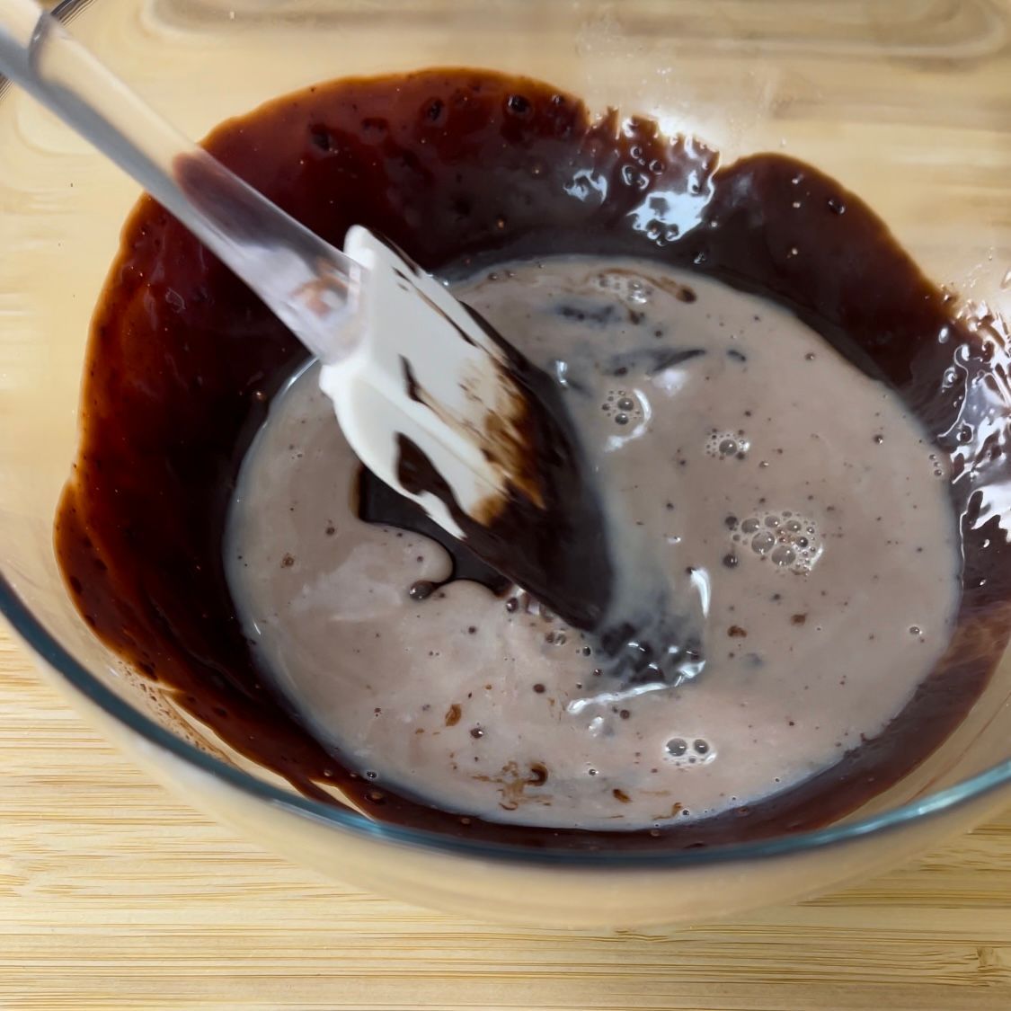 Una ciotola di salsa al cioccolato con una spatola dentro