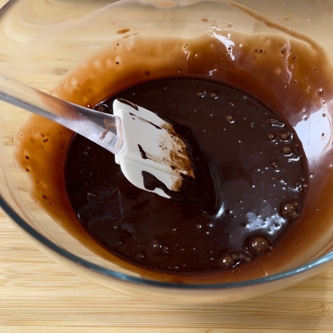 Una ciotola di salsa al cioccolato con una spatola dentro