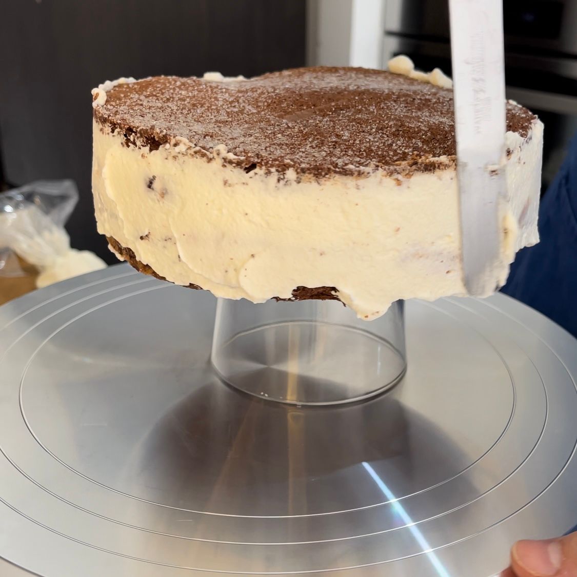 Una torta appoggiata su un supporto per torte in acciaio inossidabile