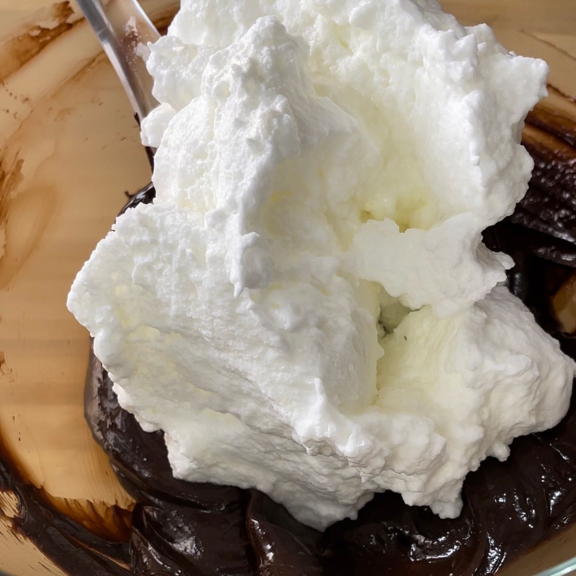 La panna montata viene versata in una ciotola di cioccolato