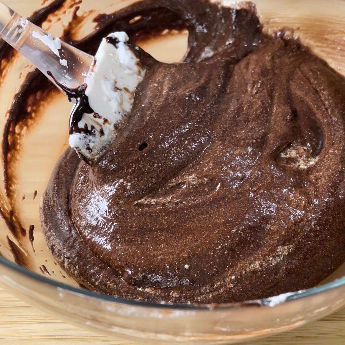 Una ciotola di glassa al cioccolato con una spatola dentro