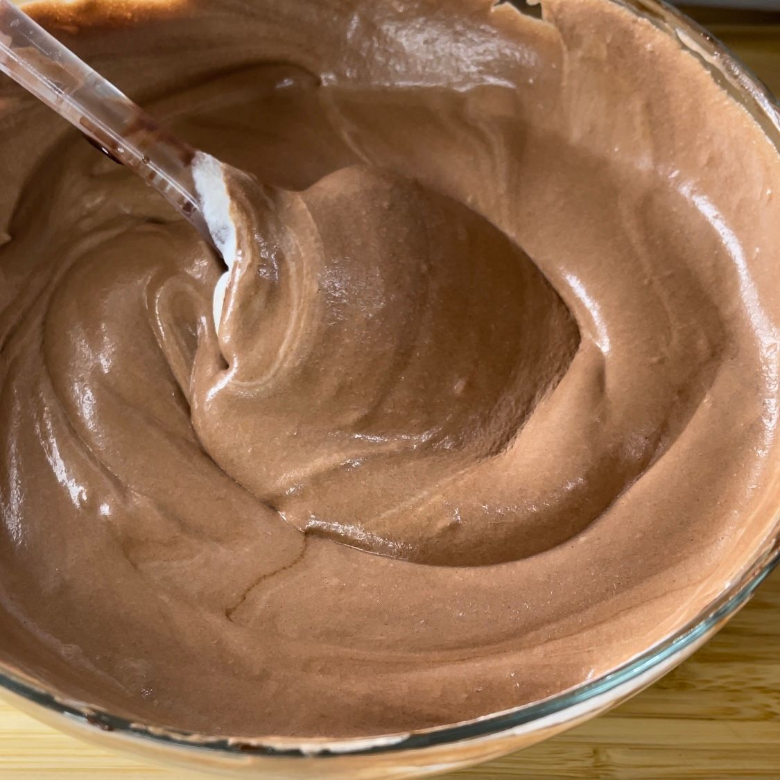 Una ciotola di glassa al cioccolato con un cucchiaio dentro