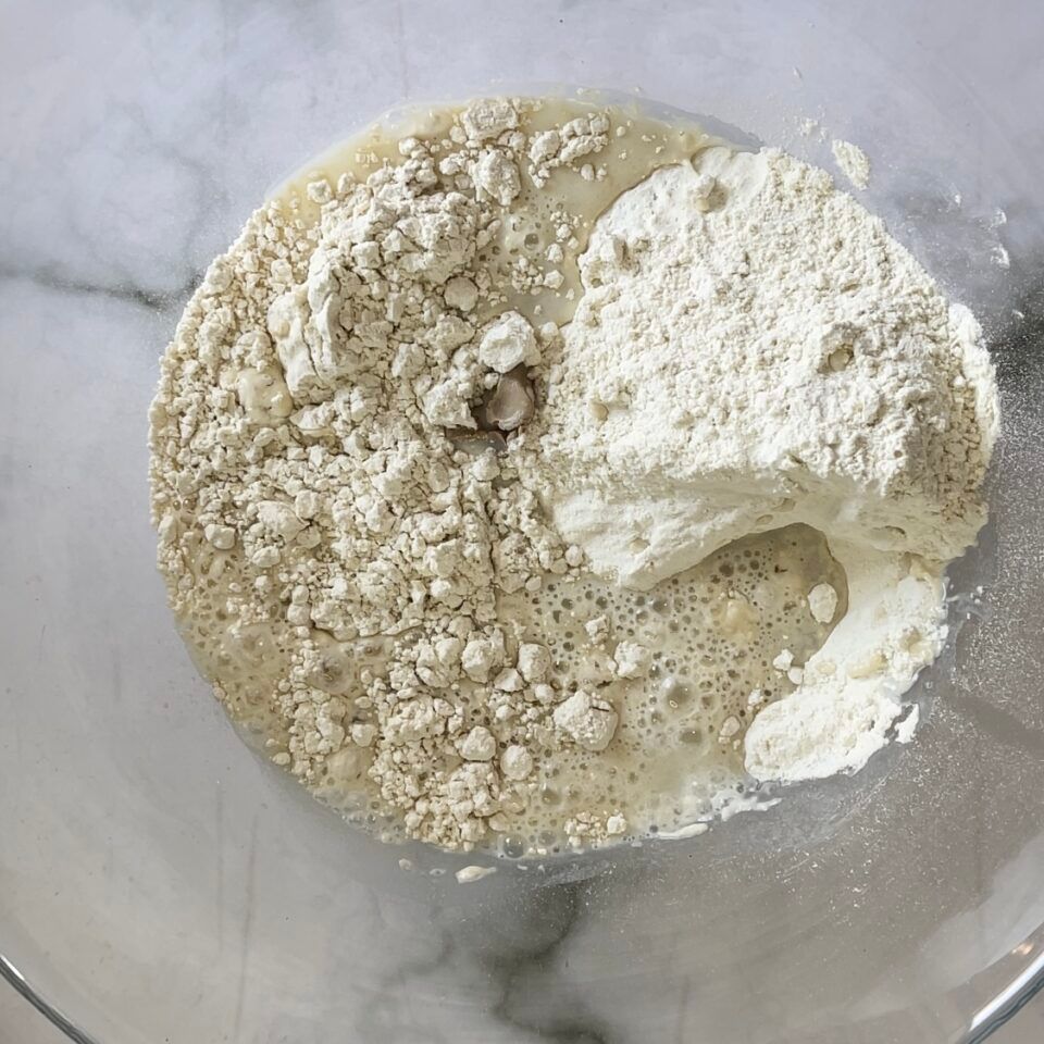 Una ciotola di vetro riempita con un composto di farina e liquido.