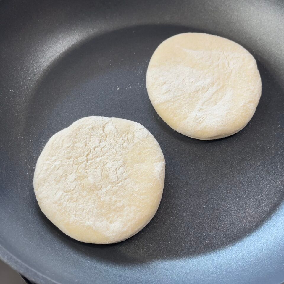 Due palline di pasta stanno cuocendo in una padella