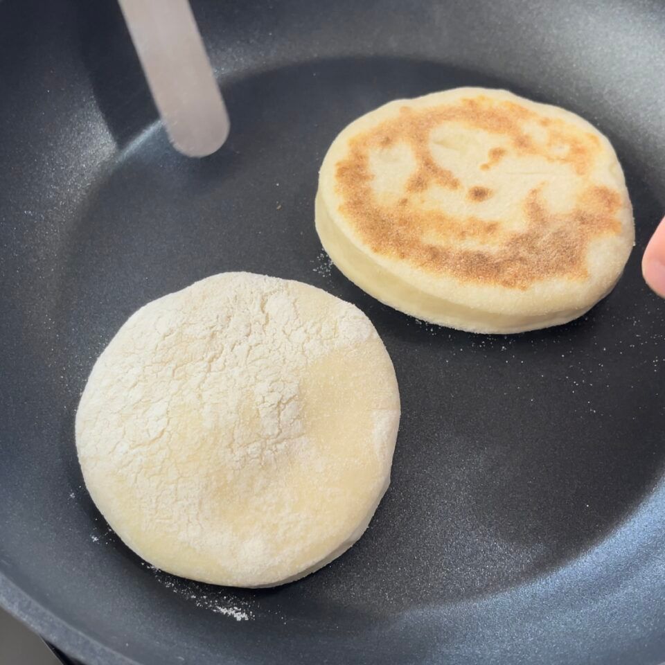 Due muffin inglesi vengono cotti in una padella