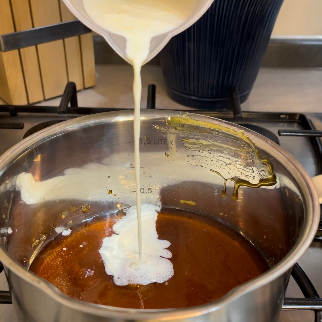 Il latte viene versato in una pentola di liquido marrone