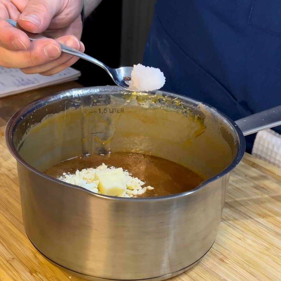 Una persona sta mescolando una pentola di salsa con un cucchiaio.