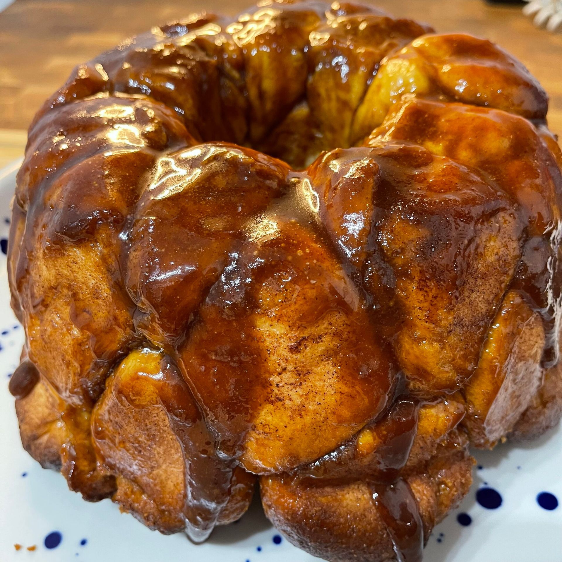 Una ciambella con glassa al cioccolato su un piatto bianco.