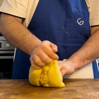 Un uomo che indossa un grembiule blu con la lettera g sopra