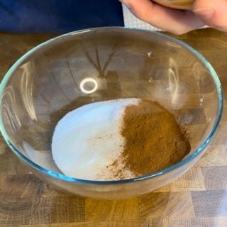 Una ciotola di vetro piena di zucchero a velo e cannella
