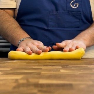 Una persona che indossa un grembiule con la lettera g sopra