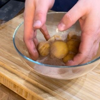 Una persona tiene in mano una ciotola di cibo su un tagliere.