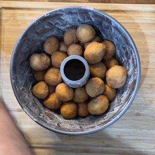 Uno stampo per ciambelle riempito con palline di pasta e un buco nel mezzo