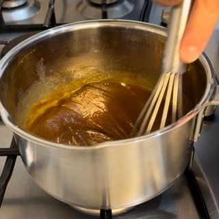 Una persona sta mescolando qualcosa in una pentola sul fornello.