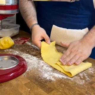 Una persona sta impastando un pezzo di pasta su un tavolo