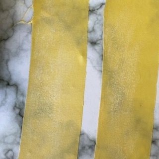 Tre pezzi di pasta sono appoggiati su una superficie di marmo.