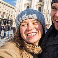 Un uomo e una donna si scattano un selfie davanti a un edificio.